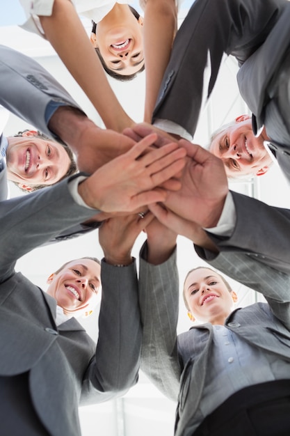 Équipe des activités debout les mains ensemble