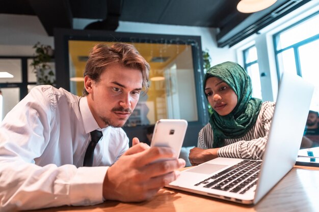 Équipe d'affaires multiculturelle internationale, un jeune homme et une femme d'affaires sont assis dans un salon de détente moderne...