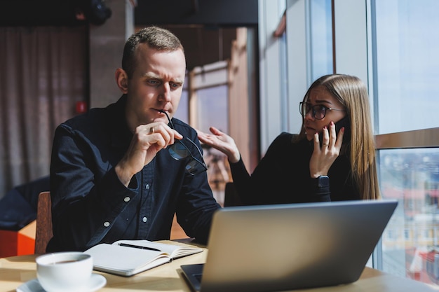 Équipe d'affaires réussie collègues masculins et féminins parlant au travail discutant d'un nouveau projet avec un ordinateur portable les jeunes cadres ont une conversation amicale coopèrent au travail d'équipe au bureau