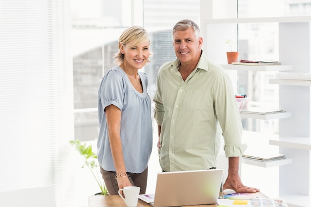 Équipe des affaires souriant en regardant la caméra