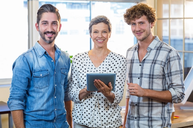 Équipe des affaires souriant regardant ensemble à la caméra