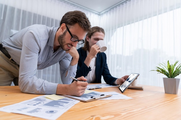 Équipe d'analystes occupée au bureau analysant l'analyse des données financières par tablette Entité