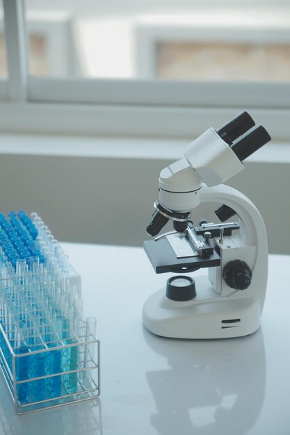 Équipe de chercheurs biochimiques travaillant avec un microscope pour le développement d'un vaccin contre le coronavirus dans la mise au point sélective du laboratoire de recherche pharmaceutique
