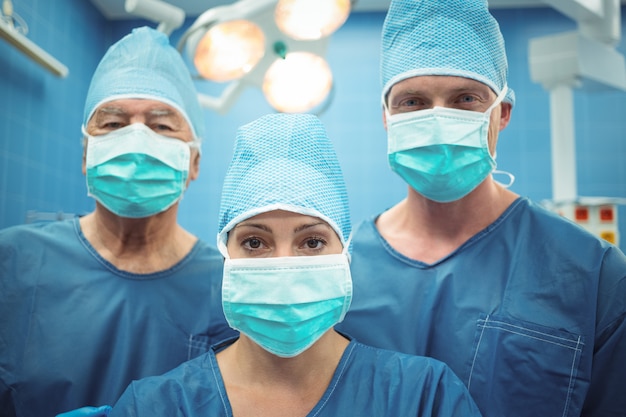Équipe de chirurgiens portant un masque chirurgical en salle d'opération