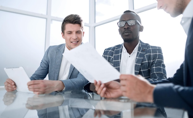 Équipe commerciale assise au bureau, le concept de travail d'équipe