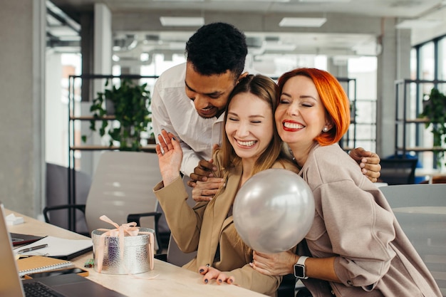 Équipe commerciale célébrant l'anniversaire d'un collègue avec un gâteau au bureau Célébrant l'anniversaire d'un employé sur le lieu de travail