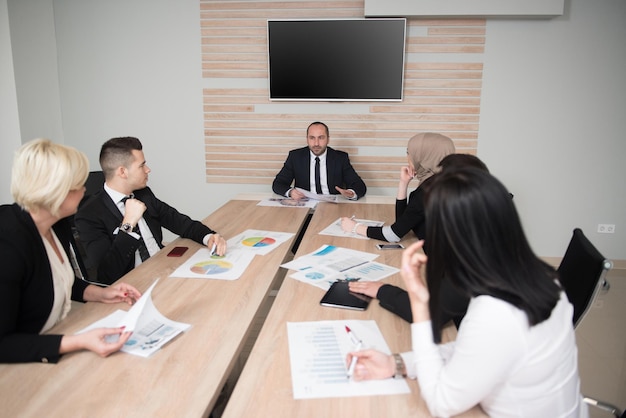 Équipe commerciale de démarrage lors d'une réunion dans un intérieur de bureau lumineux et moderne