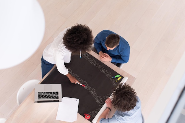 Équipe commerciale de démarrage multiethnique lors d'une réunion dans un brainstorming intérieur de bureau moderne et lumineux, vue de dessus