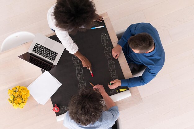 Équipe commerciale de démarrage multiethnique lors d'une réunion dans un brainstorming intérieur de bureau moderne et lumineux, vue de dessus