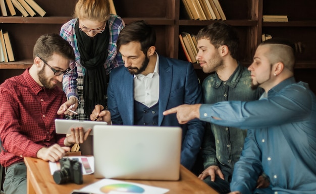 Équipe commerciale discutant d'un nouveau projet publicitaire de l'entreprise dans un bureau moderne