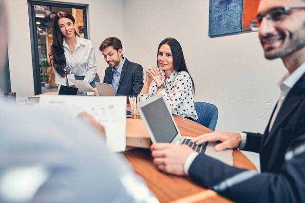 Équipe commerciale formée de jeunes hommes d'affaires assis au bureau