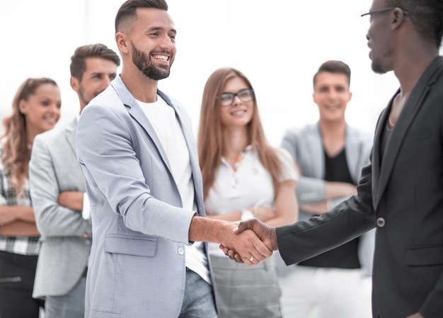 Équipe commerciale de plusieurs hommes se serrant la main et souriant