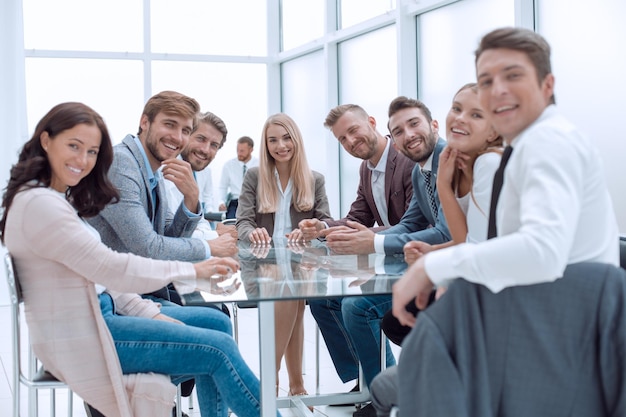 Équipe commerciale prospère assise à la table dans la salle de conférence