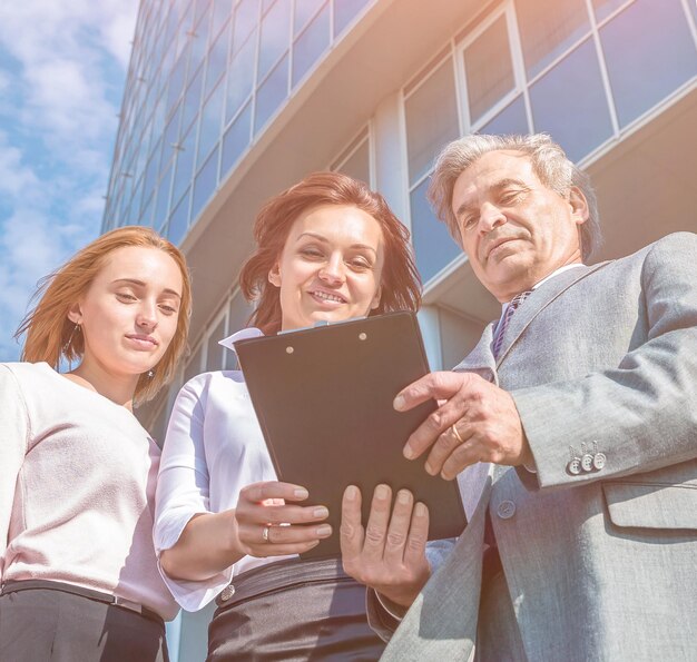 Équipe commerciale réussie avec des comprimés sur fond de bureau