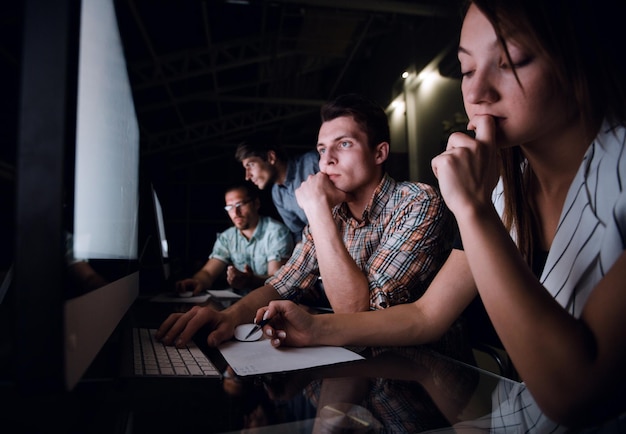 Équipe commerciale sérieuse regardant leur concept d'entreprise de moniteurs d'ordinateur