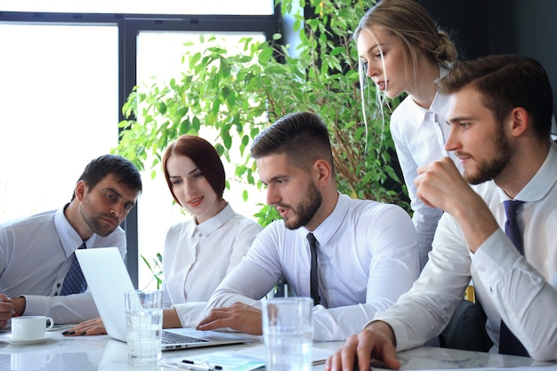 Équipe commerciale travaillant sur ordinateur portable pour vérifier les résultats de leur travail.