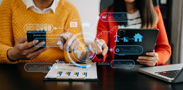 Équipe commerciale travaillant sur un smartphone moderne virtuel pour réduire les émissions de CO2, l'empreinte carbone, le changement climatique pour limiter le réchauffement climatique. Développement durable et concept d'entreprise verte au bureau