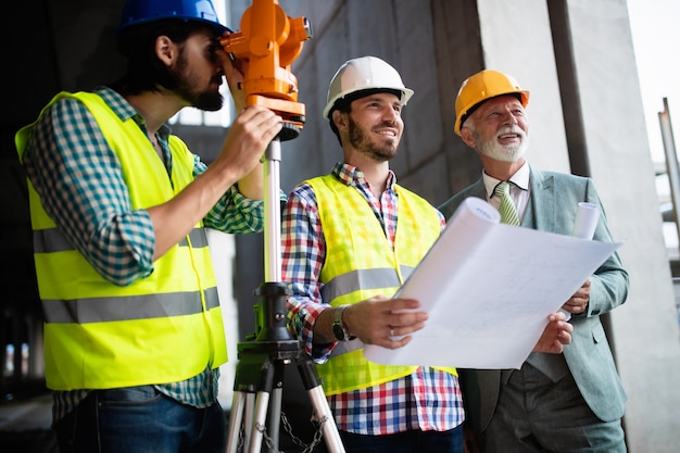 Équipe confiante d'architectes et d'ingénieurs travaillant ensemble sur un chantier de construction moderne