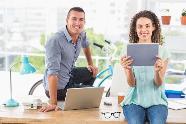 Équipe de création d&#39;entreprise souriant en regardant la caméra