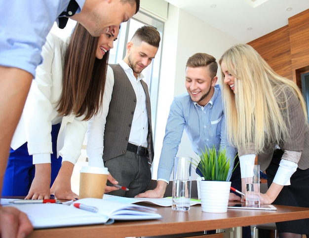 Équipe d'entreprise de démarrage lors d'une réunion dans un brainstorming intérieur de bureau moderne et lumineux, travaillant sur un ordinateur portable et une tablette