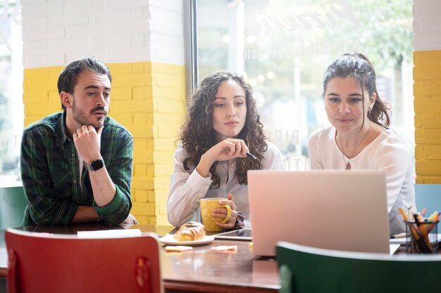 Équipe d'étudiants universitaires étudiant ensemble sur un nouveau projet dans une classe de coworking créatif Filtre lumineux mettant l'accent sur la femme au centre