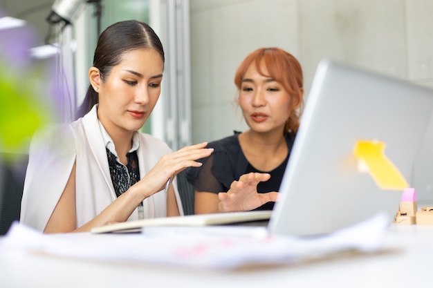 Équipe de femmes d'affaires asiatiques travaillant sur un ordinateur portable dans la salle de réunion. Concept de remue-méninges et de travail d'équipe de gens d'affaires professionnels.