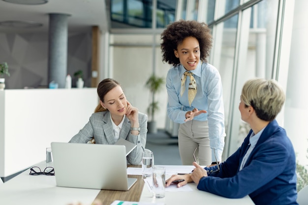 Équipe de femmes entrepreneurs communiquant lors d'une réunion d'affaires au bureau