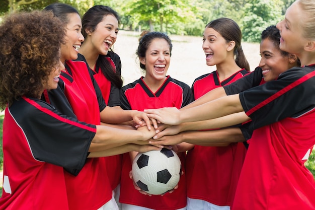 Équipe de football excité empiler les mains sur la balle