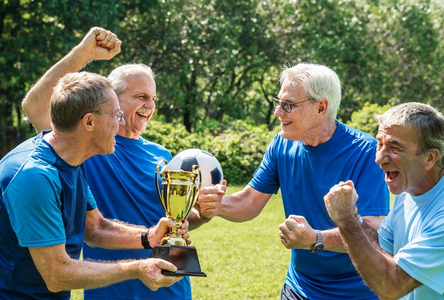 Équipe de footballeurs matures remportant la coupe