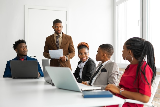 Équipe de jeunes africains au bureau à la table avec un ordinateur portable