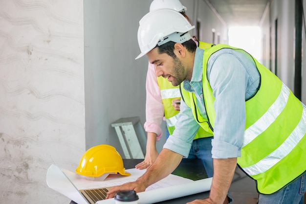 Équipe de jeunes entrepreneurs caucasiens, asiatiques, homme et femme, partenaire expliquant et inspectant la construction reconstruite et l'appartement rénové, la maison ou la maison sur le chantier, le lieu de travail. Concept de travail d'équipe.