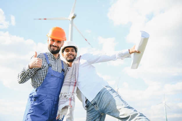 Équipe de jeunes ingénieurs de maintenance travaillant dans un parc éolien