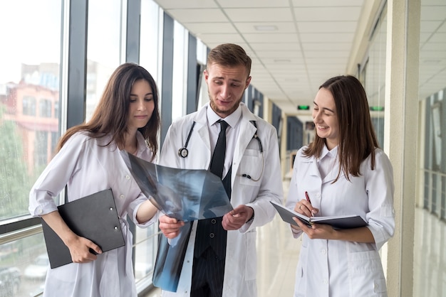 Équipe de jeunes médecins à la recherche d'un film radiographique thoracique d'un patient pour le virus covid avant le traitement. Notion de santé