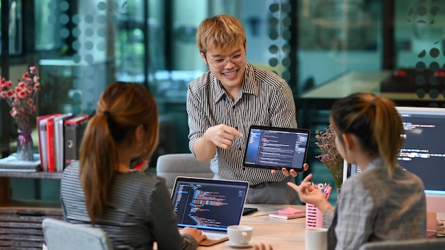 Équipe de jeunes professionnels faisant ensemble un brainstorming de programmation de code pour un nouveau projet de site Web