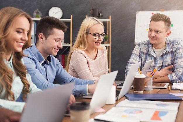 Équipe de jeunes programmeurs avec chef d'équipe travaillant dans une entreprise de développement de logiciels, discutant d'un nouveau projet, espace de copie