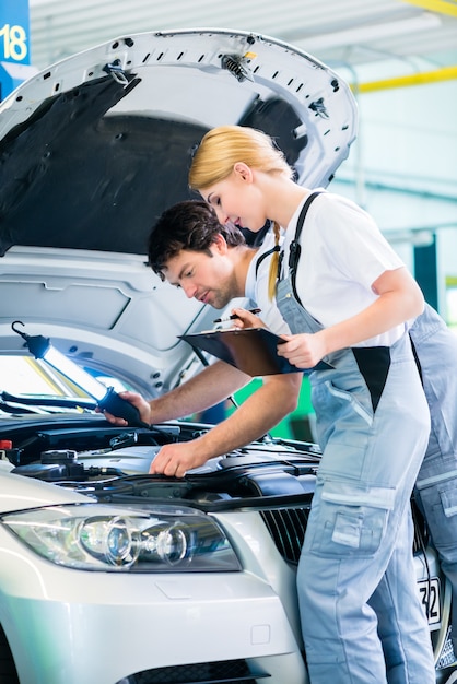 Équipe de mécanicien travaillant dans un atelier automobile