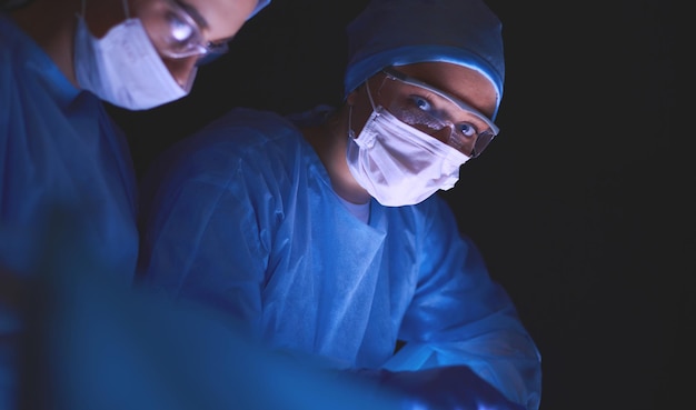 Équipe de médecins en chirurgie sur fond sombre