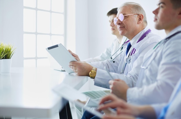 Équipe médicale assise et discutant à table