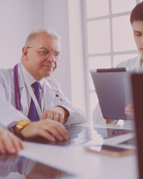 Équipe médicale assise et discutant à table