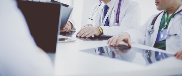 Équipe médicale assise et discutant à table