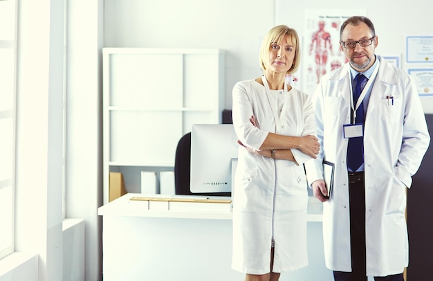 Équipe médicale sérieuse utilisant un ordinateur portable dans un bureau lumineux