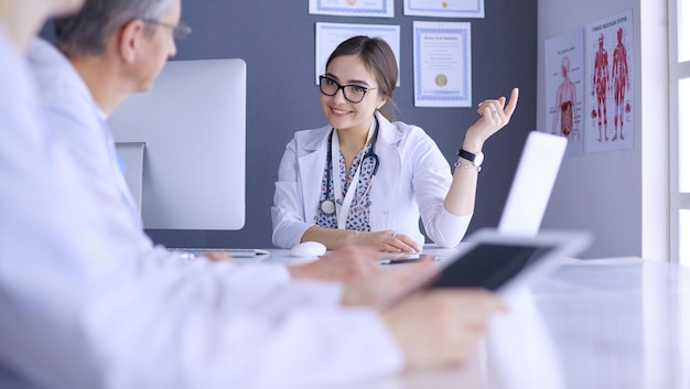 Équipe médicale sérieuse utilisant un ordinateur portable dans un bureau lumineux