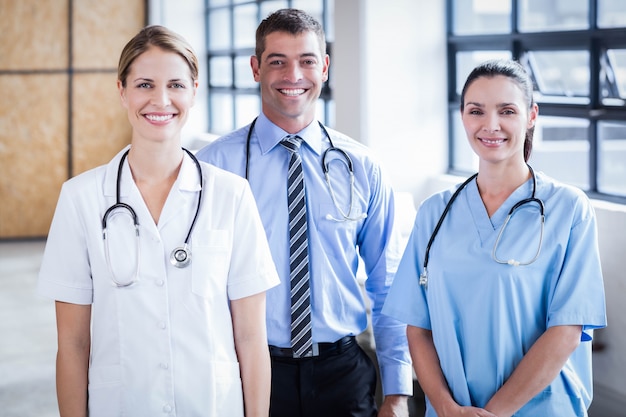 Équipe médicale souriant à la caméra ensemble à l'hôpital