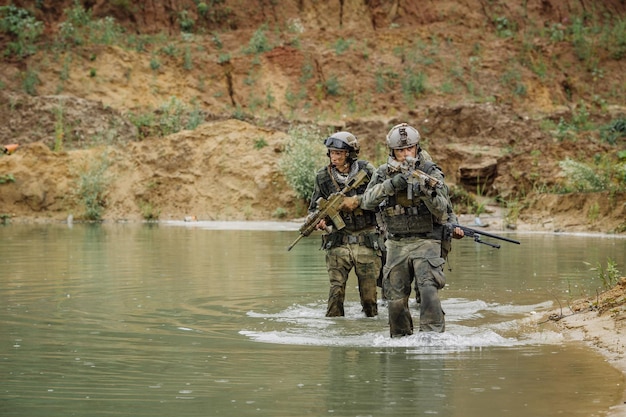 Équipe militaire traversant la rivière sous le feu