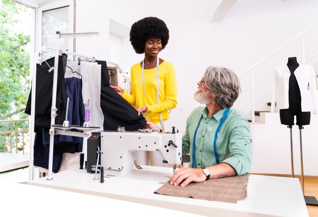 Équipe multiethnique de créateurs de mode travaillant dans un atelier de création de vêtements - Groupe multiracial de stylistes, de couturiers et de couturiers travaillant sur une nouvelle collection