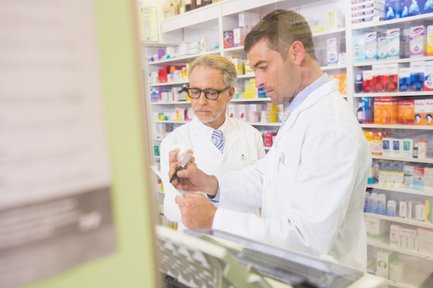 Équipe de pharmaciens écrivant sur le presse-papiers