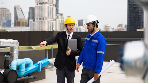 Équipe professionnelle Homme d'affaires asiatique jeune PDG et ingénieur en énergie planifient un projet de construction d'un panneau solaire pour le bâtiment en construction concept d'énergie alternative propre et verte