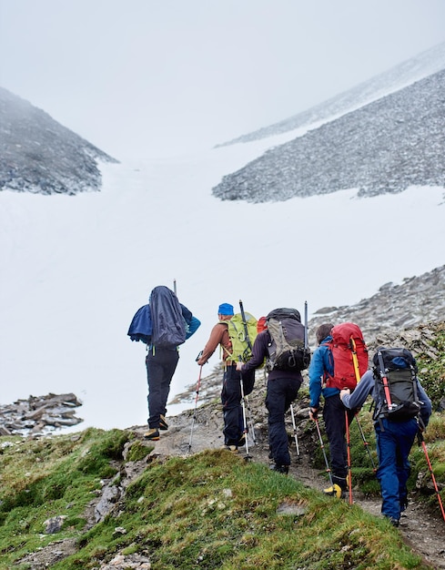 Équipe de randonneurs marchant sur un chemin de montagne.