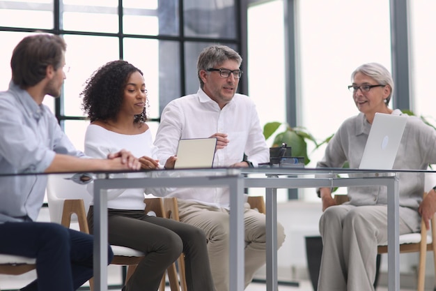 Équipe sérieuse de professionnels professionnels négociant dans une salle de conférence moderne