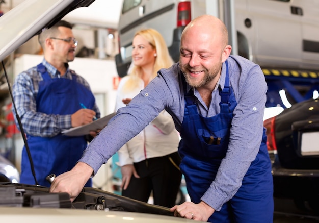 Équipe de service et chauffeur près de la voiture